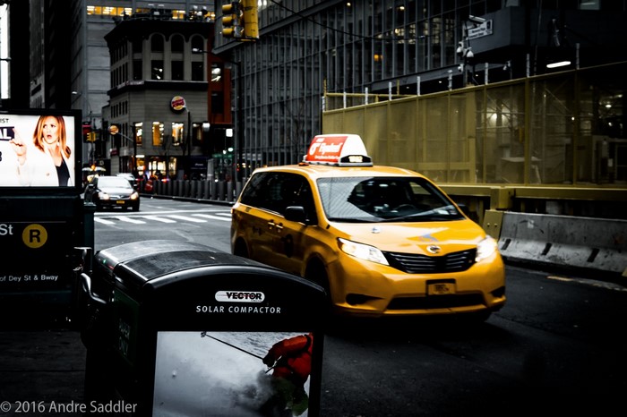 Yellow taxi on a city street with Burger King sign