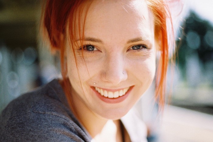 Close-up portrait of a smiling redhead woman with blue eyes