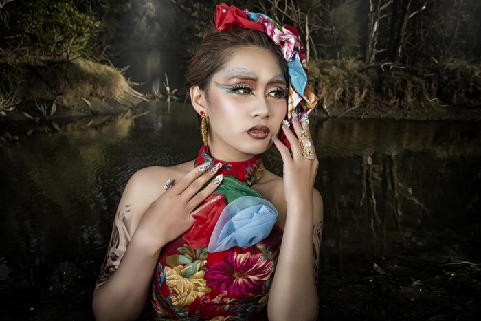Woman with elaborate makeup and floral dress in water