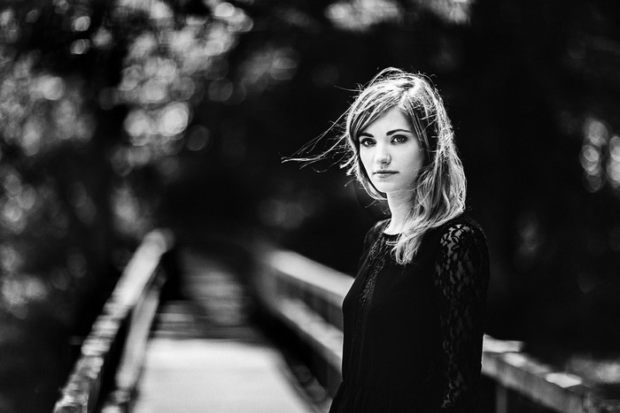 Black and white portrait of a woman on a bridge