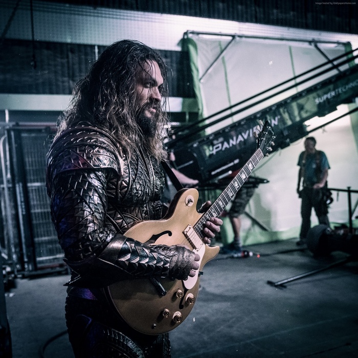 Jason Momoa as Aquaman playing guitar on set