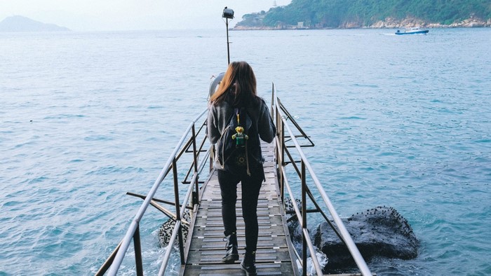 Woman walking on a pier over the sea