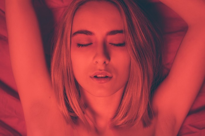 Close-Up Portrait of Woman with Closed Eyes in Red Light