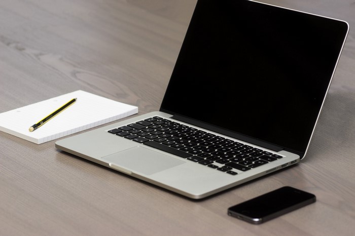 Apple MacBook, iPhone, and notepad with pencil
