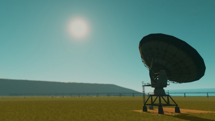 Satellite dish in a grassy field under the sun