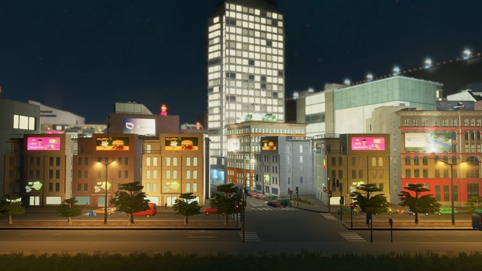 Cityscape at night with illuminated buildings and billboards