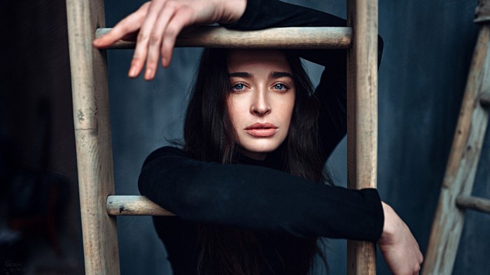 Woman in black turtleneck leaning on a ladder