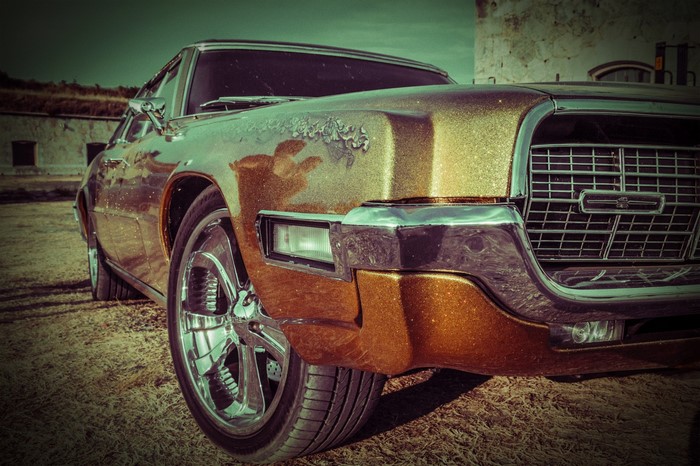 Gold 1960s Ford Thunderbird parked outdoors