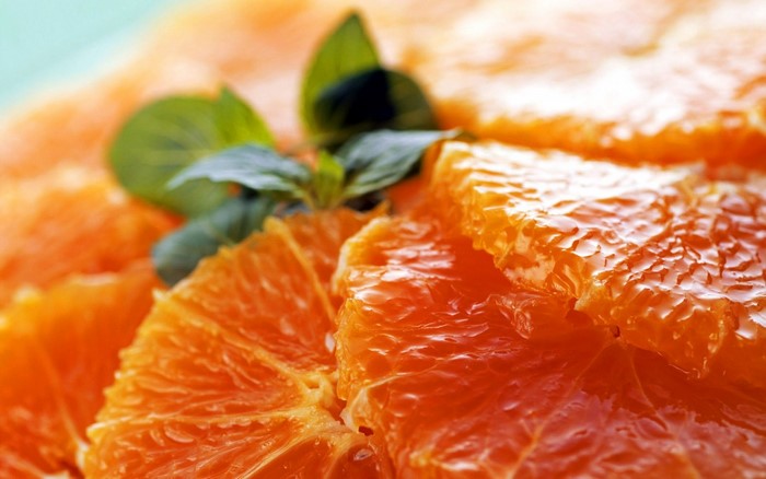 Close-up of Fresh Tangerine Slices with Green Leaves