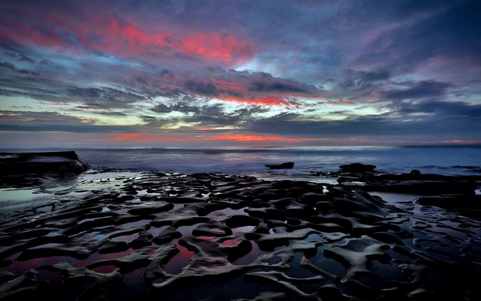 Rocky Shoreline at Sunset with Colorful Clouds