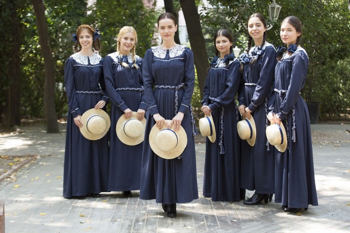 Group of women in traditional Turkish attire holding hats