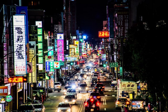 Busy street at night with neon signs and traffic