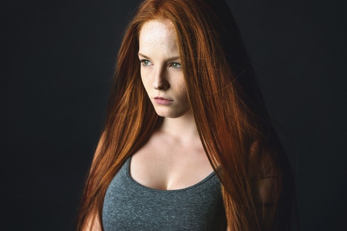 Portrait of a young woman with long red hair and freckles
