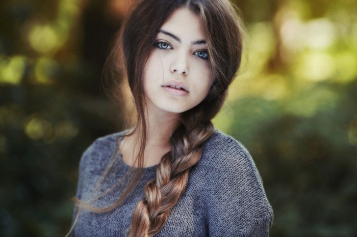 Portrait of a young woman with blue eyes and braided hair