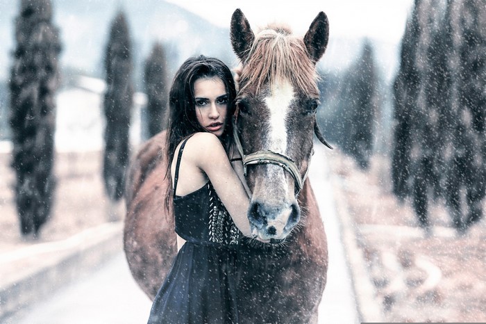 Woman embracing a horse in the snow