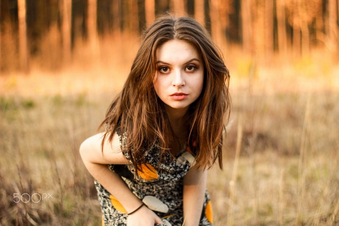Woman with long brown hair in a dress outdoors