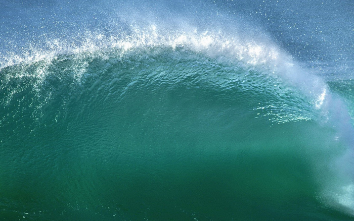 Ocean wave breaking with sunlight and spray