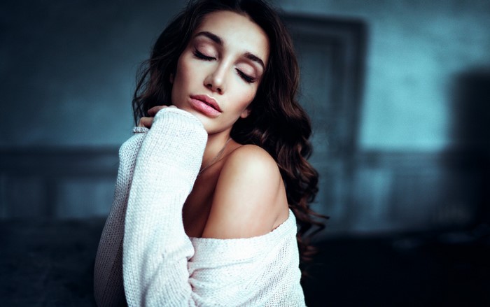 Woman with brown hair wearing a white sweater