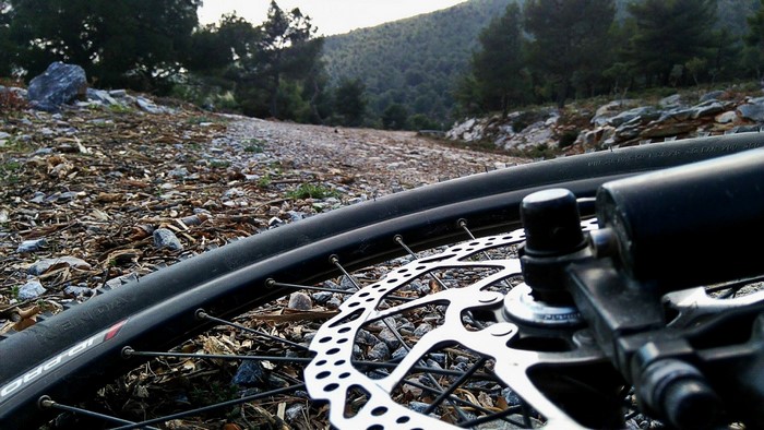 Close-up of a mountain bike wheel on a rocky trail