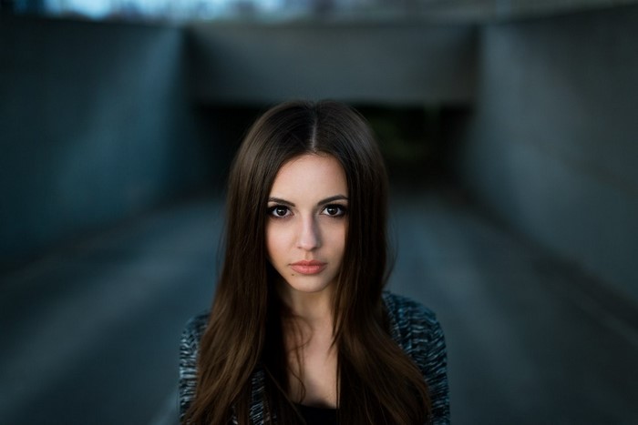 Woman with long brown hair in a dark tunnel