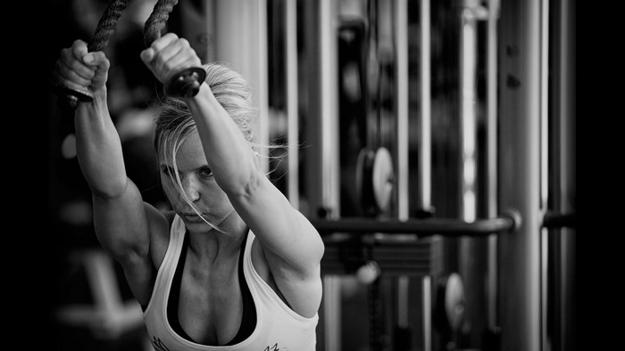 Woman performing triceps pushdowns in a gym