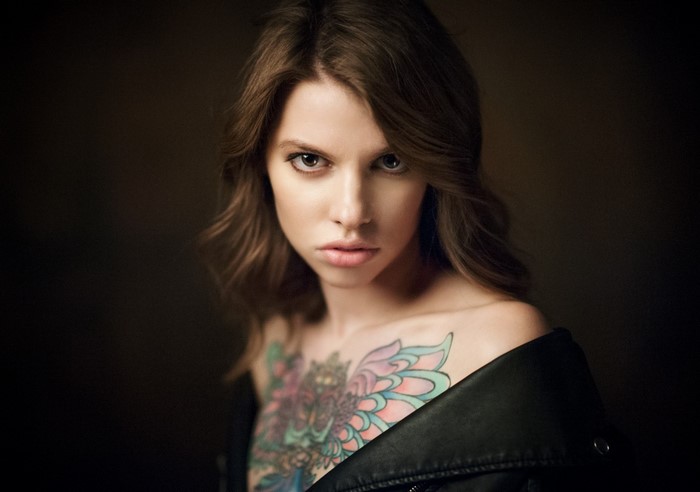 Woman with chest tattoo and leather jacket
