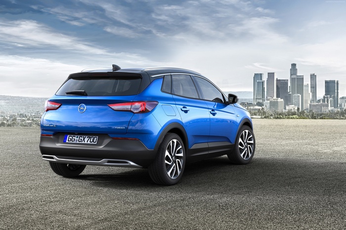 Blue Opel Grandland X crossover with city skyline
