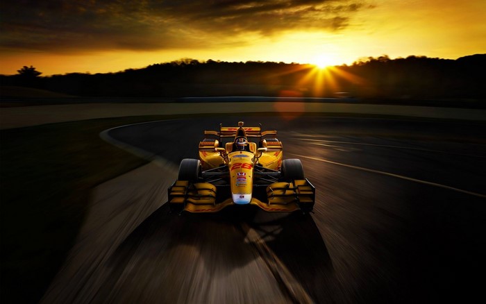 Yellow IndyCar racing at sunset