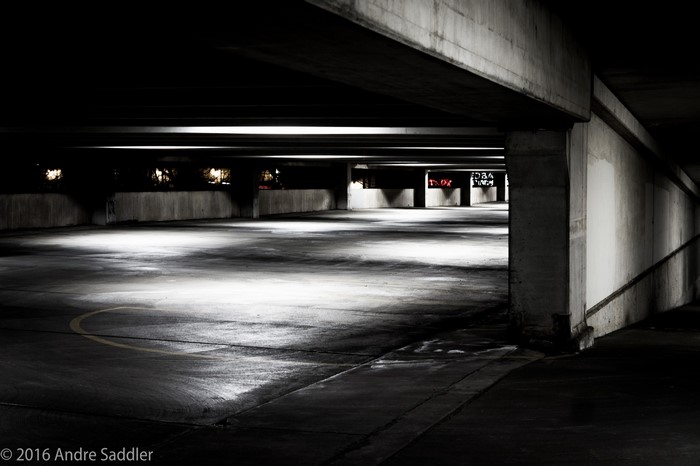 Empty parking garage at night with dramatic lighting