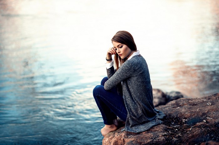Woman sitting by the water