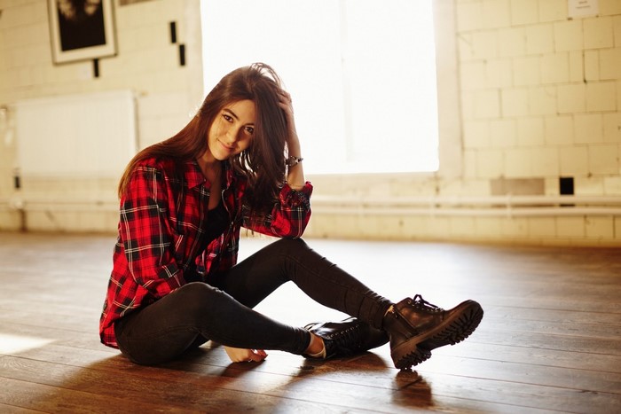 Woman in red plaid shirt sitting on floor