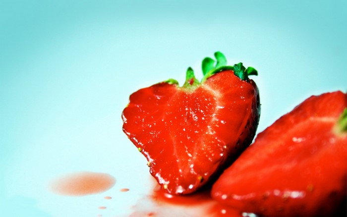 Close-up of two sliced strawberries with juice