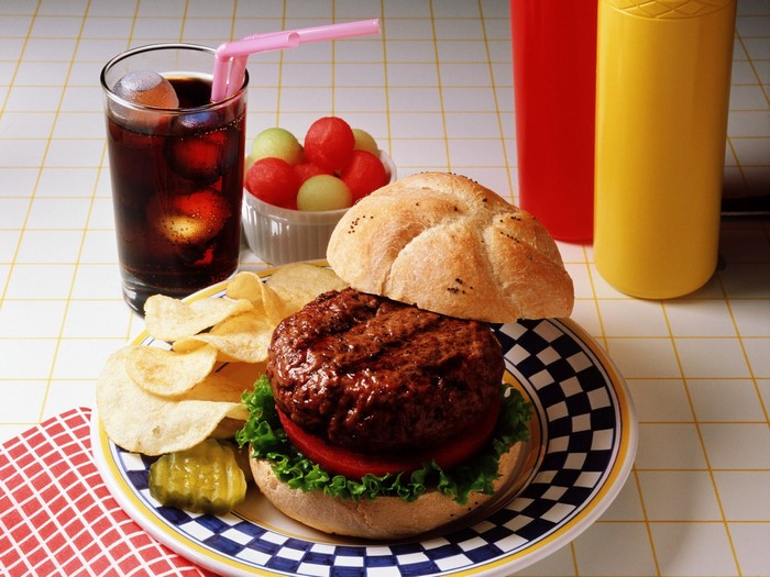 Hamburger with chips, soda, and fruit salad