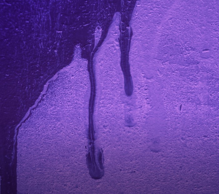 Purple drips on a textured surface