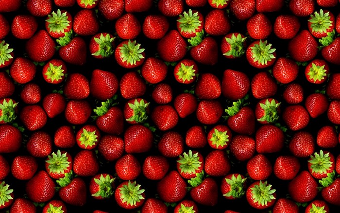 A pattern of fresh red strawberries with green leaves