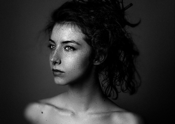 Monochrome portrait of a woman with freckles and nose ring