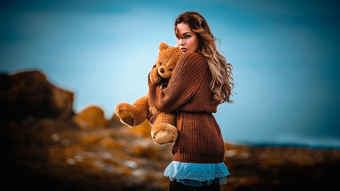 Woman holding a teddy bear outdoors