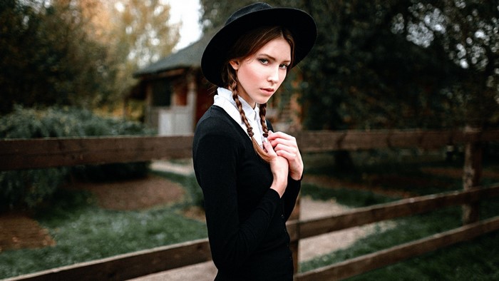 Woman in black dress and hat with braids