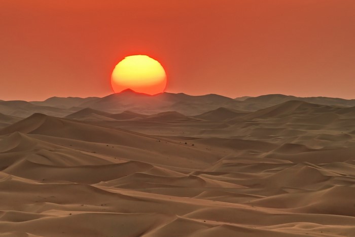 Desert landscape at sunrise with rolling sand dunes