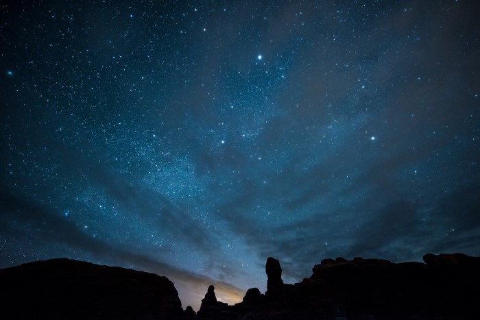 Silhouette of rock formations under a starry night sky