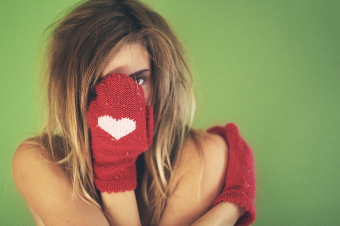 Woman wearing red mittens with heart