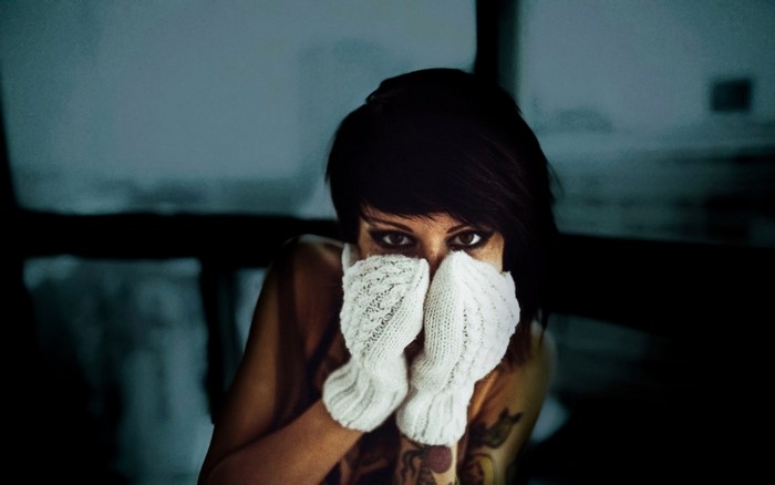 Woman with short black hair wearing white mittens