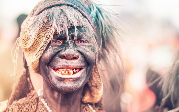 Person with face paint and headdress at a festival