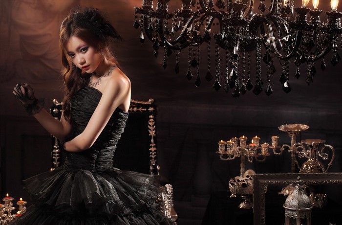 Woman in black dress with gloves and necklace