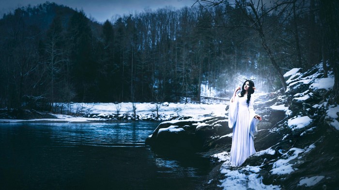 Woman with antlers by a winter river