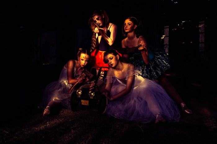 Four women in ballet costumes with makeup and props