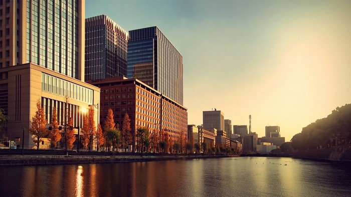 Cityscape with skyscrapers and a river at sunset