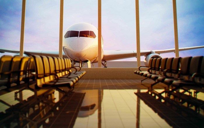 Airplane at airport gate with empty waiting chairs