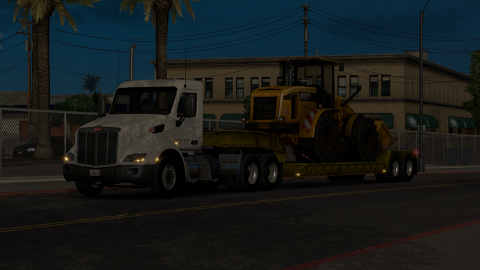 Peterbilt truck carrying a wheel loader in American Truck Simulator