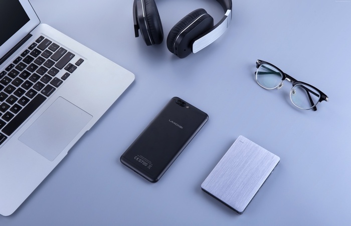 UMi Z PRO smartphone with laptop, headphones, and glasses